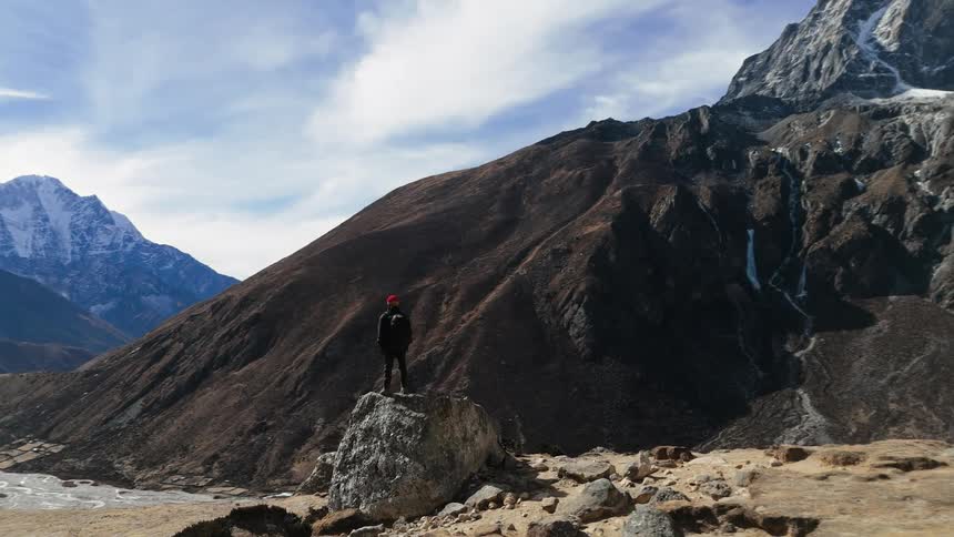 A person on top of a mountain admiring the valley landscape