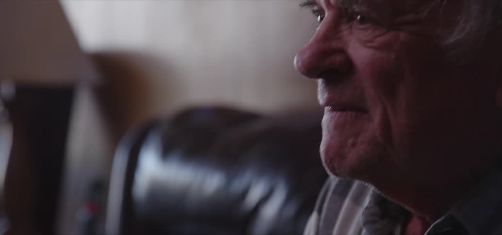 An elderly man playing video games alone at home