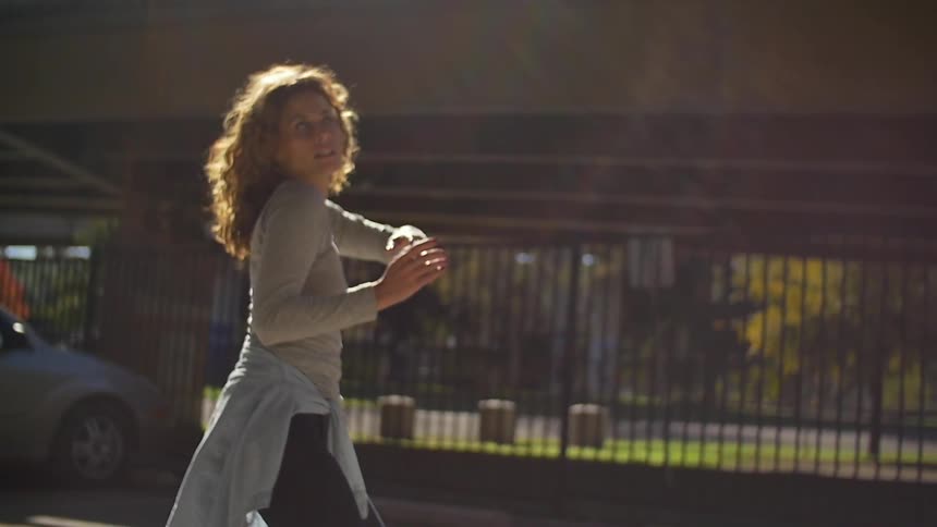 Woman doing expressive dancing outside in city parking lot