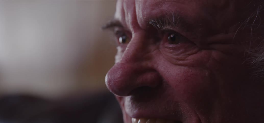 An old man listens and laughs