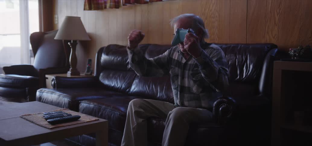 Elderly man sitting vibrating a lot while playing video games