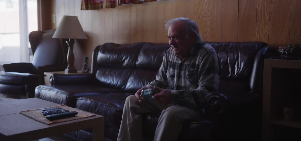 An elderly man having fun playing video games alone