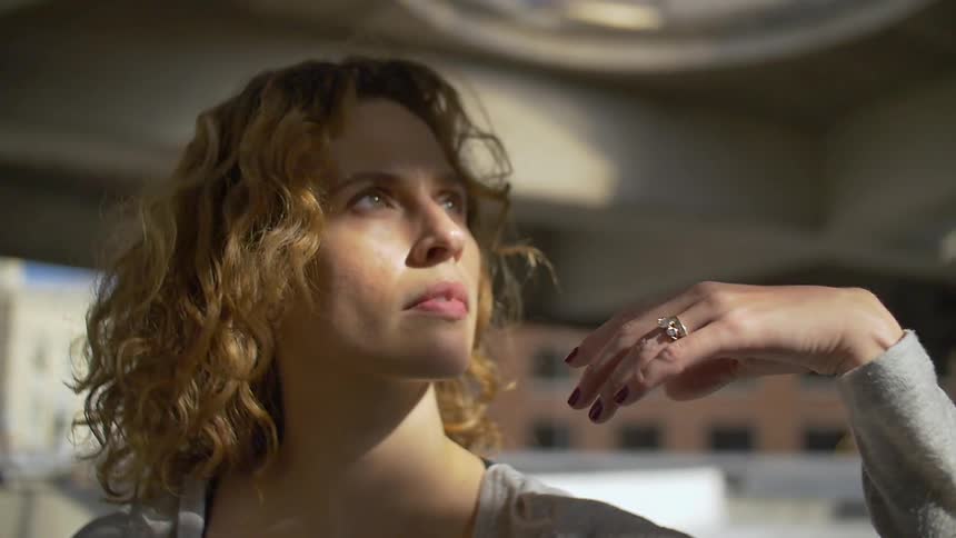 Sunlight shines on a woman's face as she lifts her hand