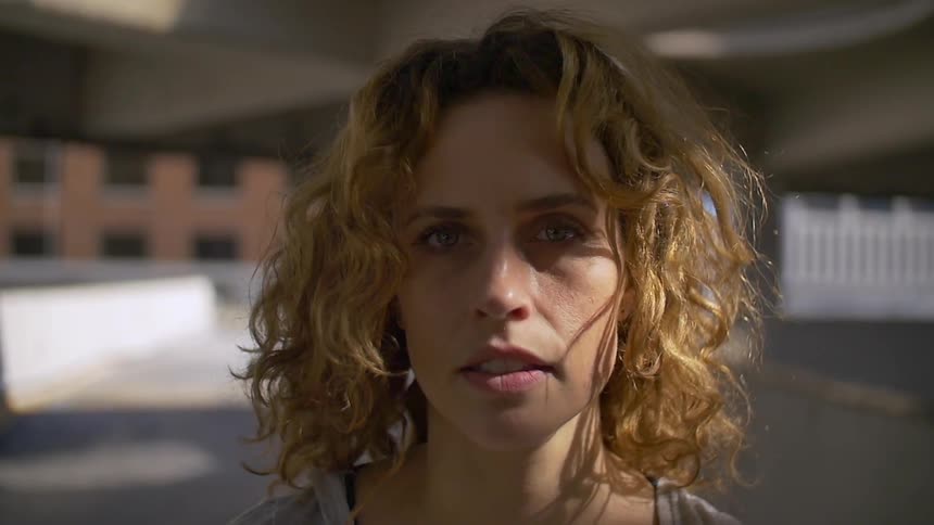 A woman staring at the camera as someone holds it near her