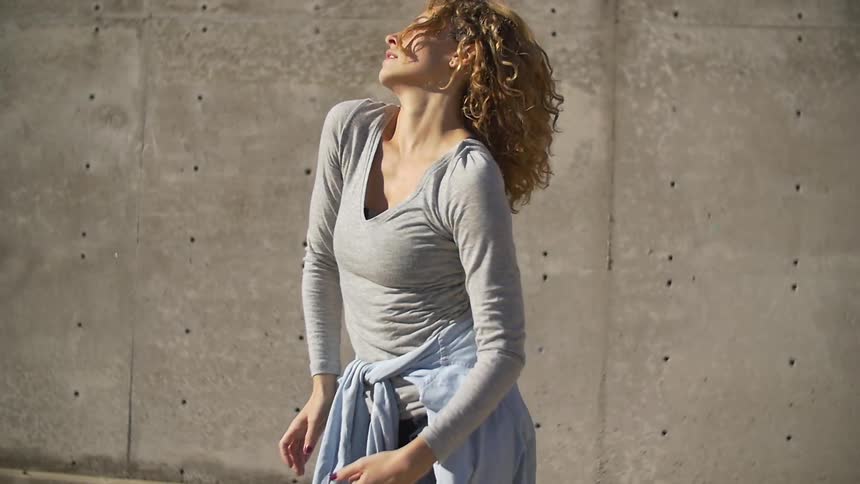 A woman dancing around in place outside in a secluded area