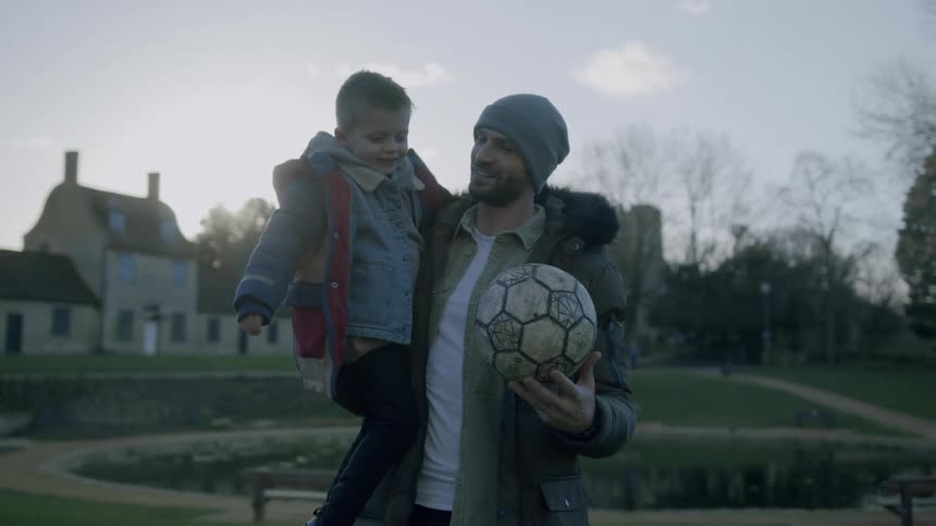 Father holding his little son on his lap and receiving a hug