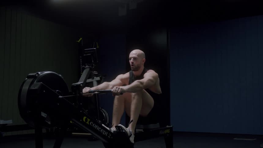 Man on a gym machine pulling a rope on a warmup and cardio machine