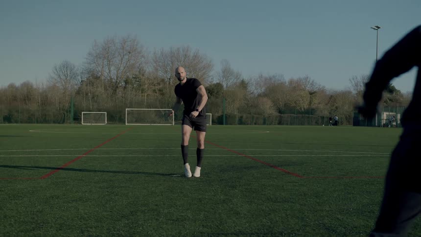 Man taking a penalty kick and scoring the goal and cheering