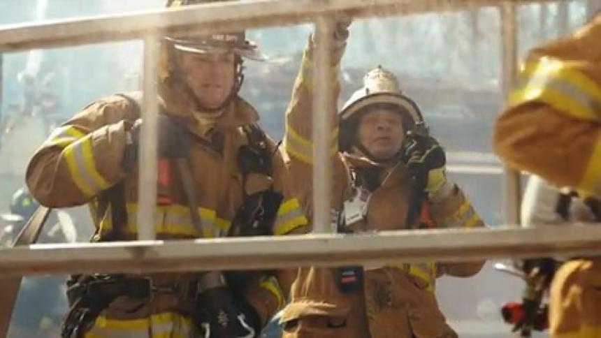 Firefighters in an external environment carrying ladders using water and slow motion
