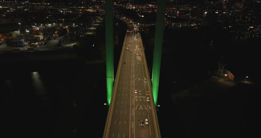 An aerial view of a bridge with two highways full of cars at night