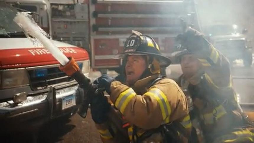 Firefighters outdoors spraying water upwards