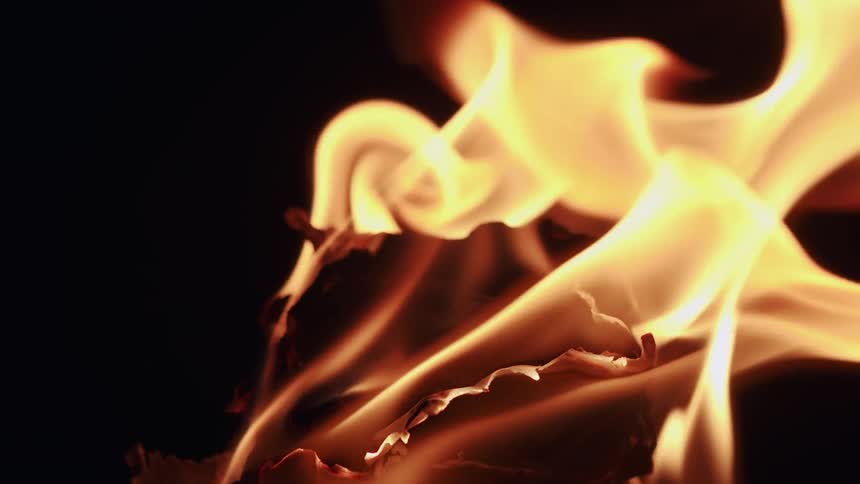 Fire burning paper on a black background