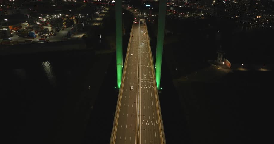 Cars crossing a highway bridge with green pillars