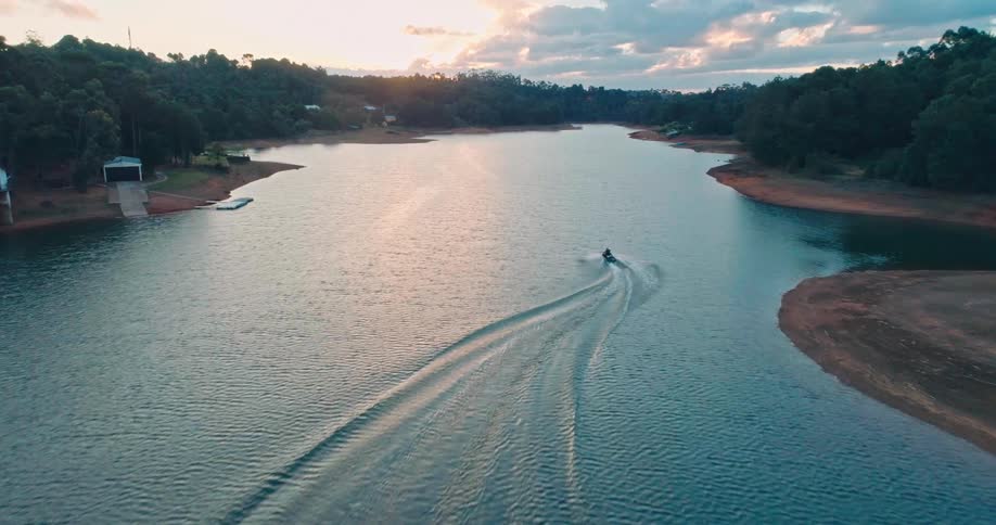 Horizon of a person on a jet ski on a river during sunset
