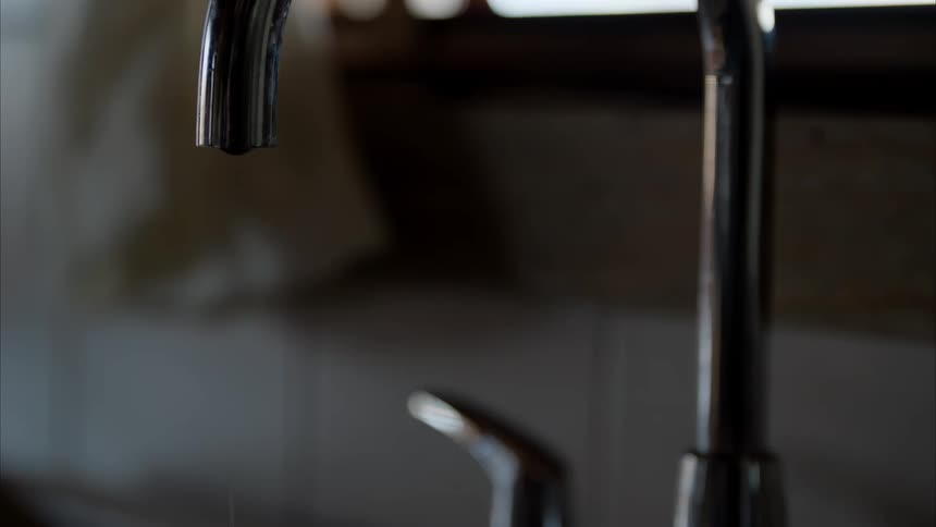 Water drips from a water faucet