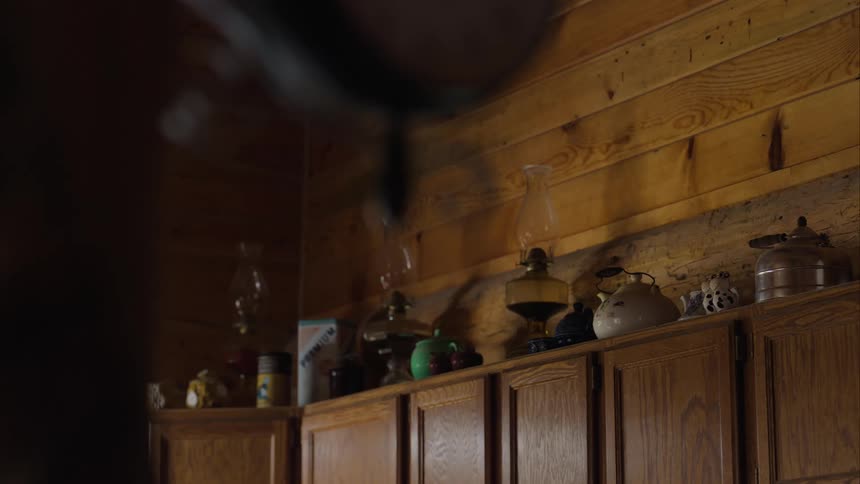 Wooden cabinet with various utensils on top including kettles and glass hypothesis