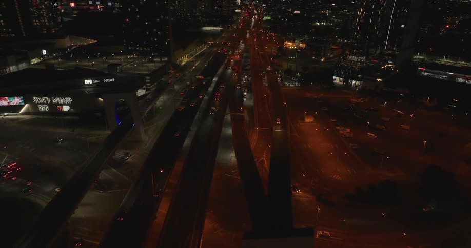 Skyline of cars driven across a suspension bridge in the city at night