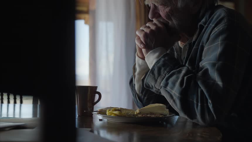 A clip of an old man contemplating on the dinning