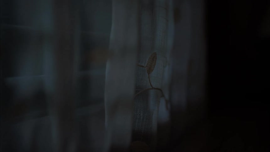 Closeup of the curtain on a window that slowly moves due to the force of the wind in a dark room at night