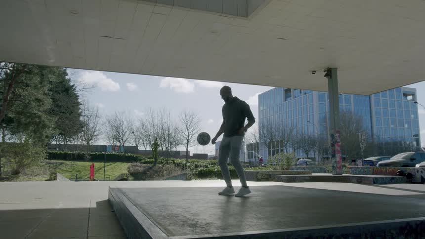 A man dribbling a soccer ball outdoors
