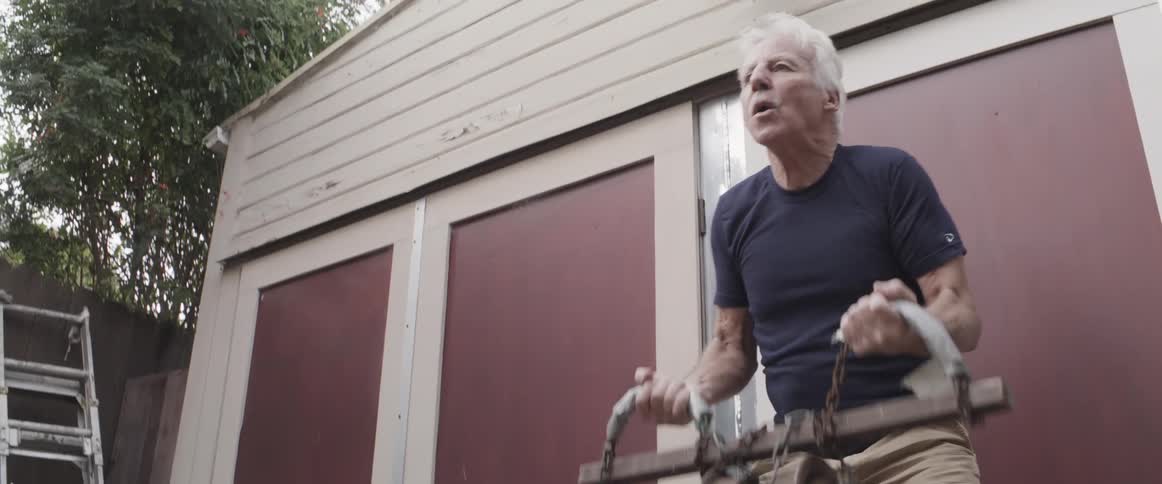 Elderly person using home weight lifting and training outside the house