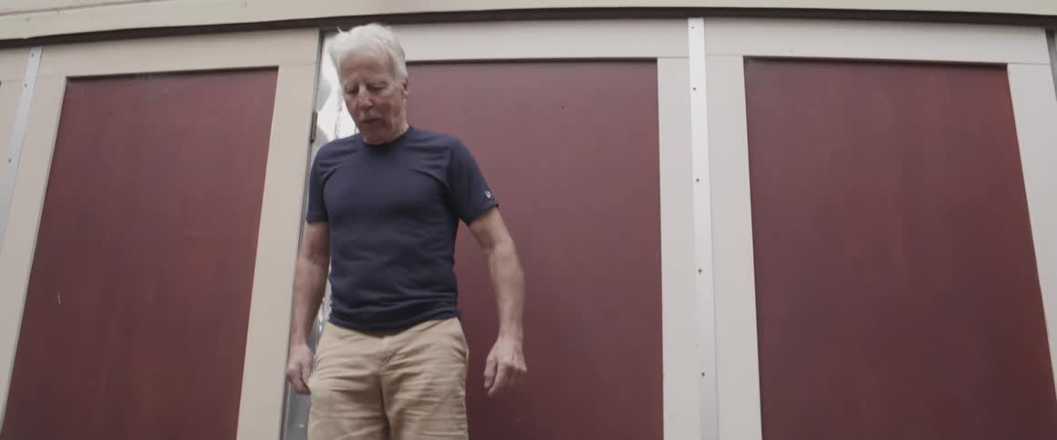 Elderly man wearing artificial boots and walking side to side