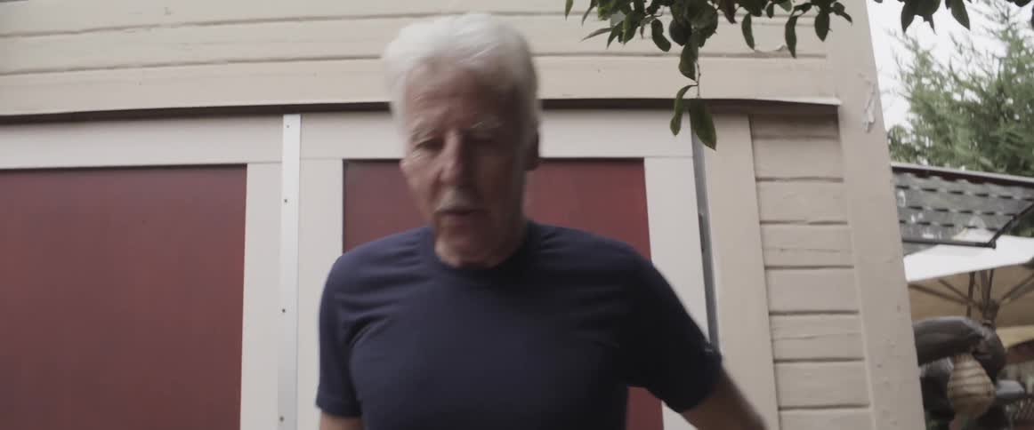 Elderly man wearing weighted boots and walking