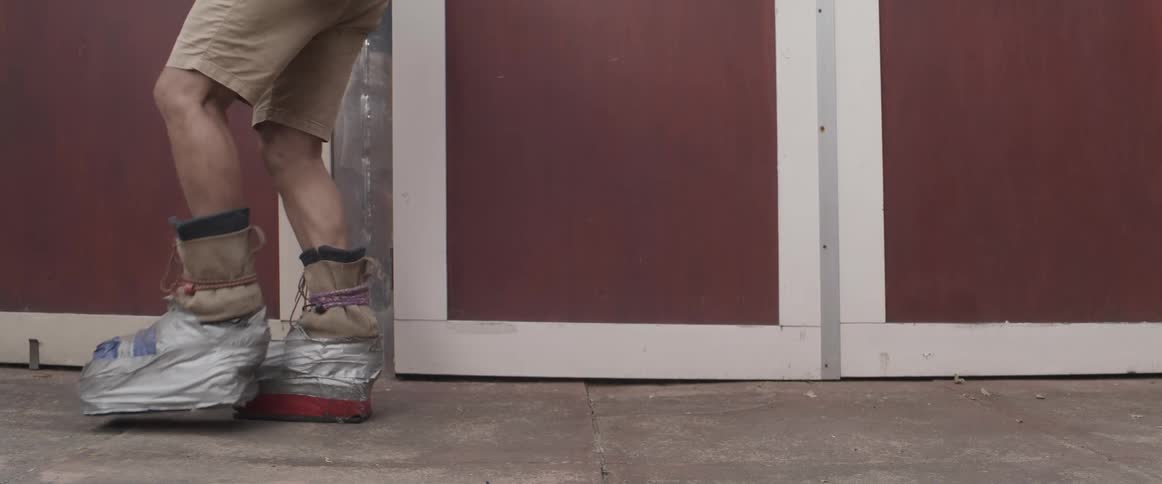 A person walking with boots tied with ribbons