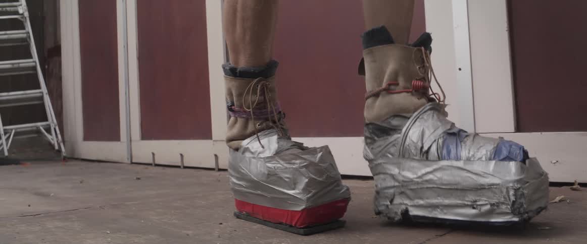 A clip of an old man exercising with a heavy footwear
