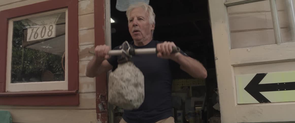 A man is lifting a stone outside