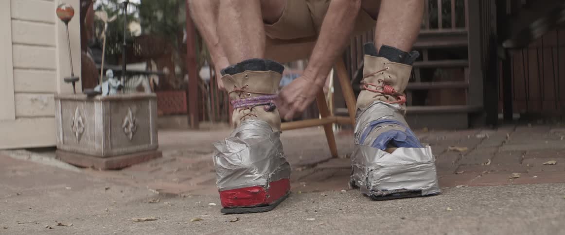 A person strapping protection onto boots