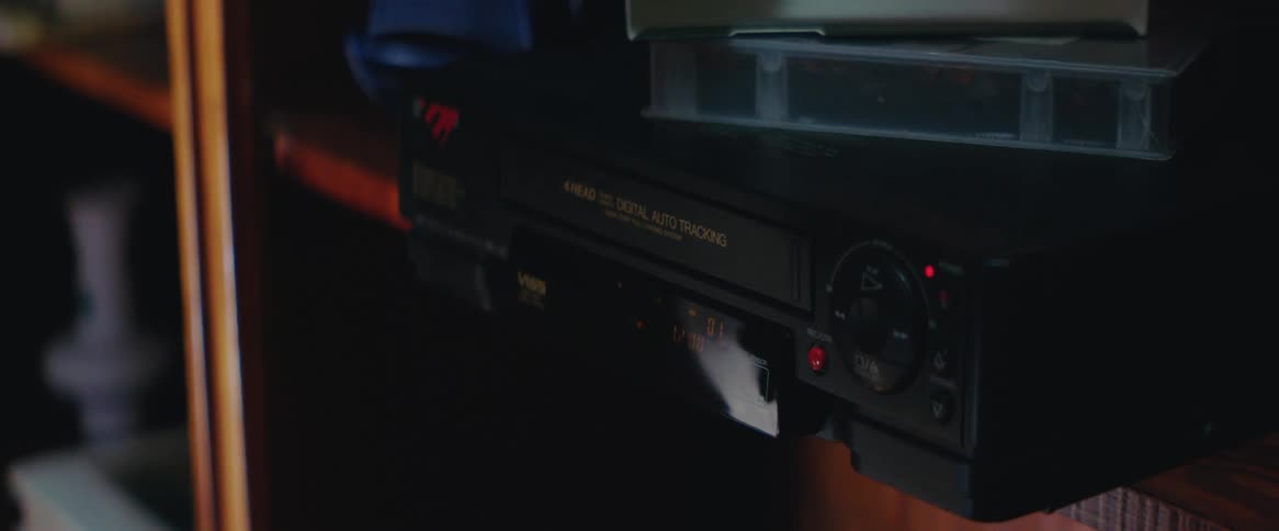 A hand turns on a vcr