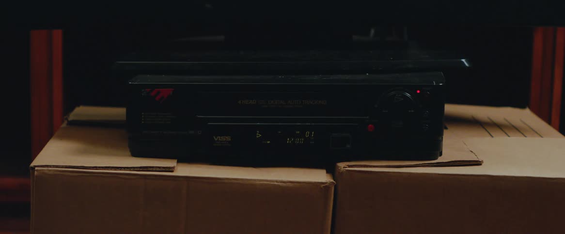 A human hand putting a tape into a black vhs