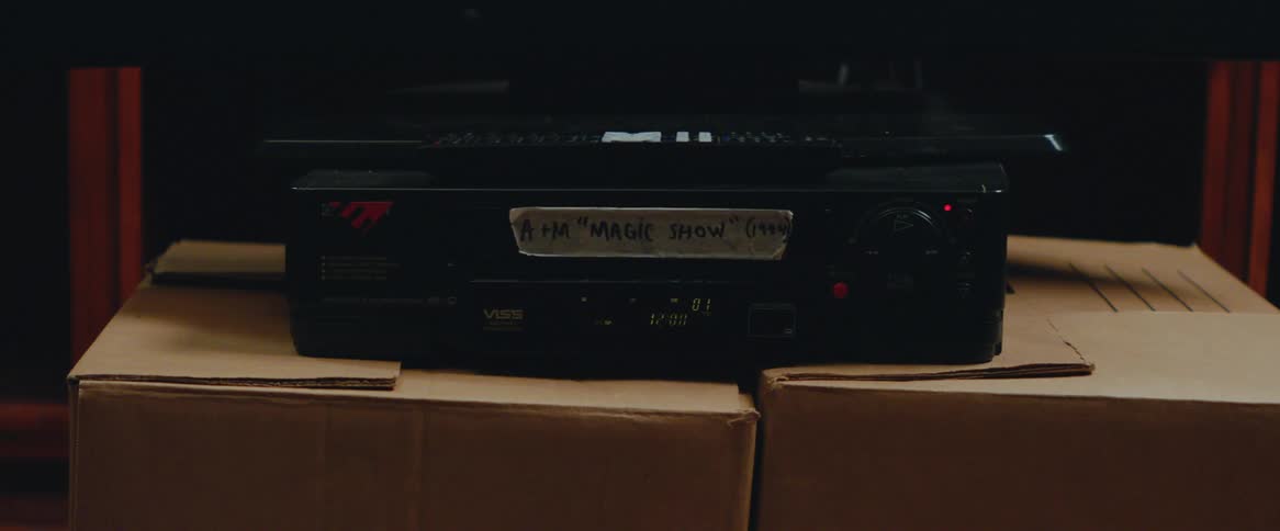 A man takes a vhs tape out of a video recorder