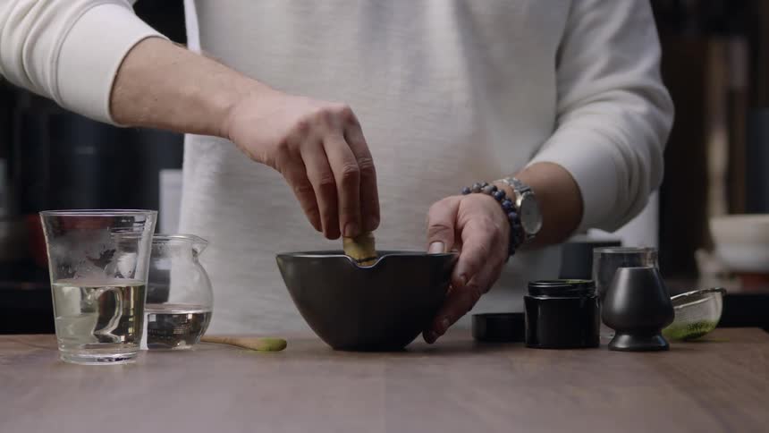 Hands of a man with a small pot stirring circular motion