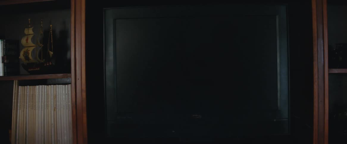 Vintage television on a deck on a wooden bookcase