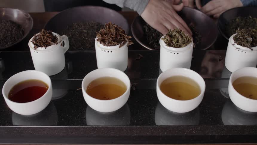 Two people prepare bowls of herbal tea
