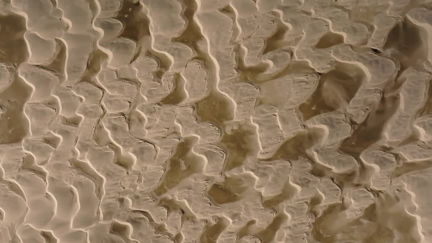 An ivory colored abstract with wavy lines and ridges