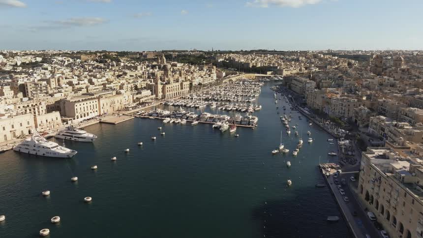 Aerial panorama of an ancient city with a central canal with boats attacked in docks