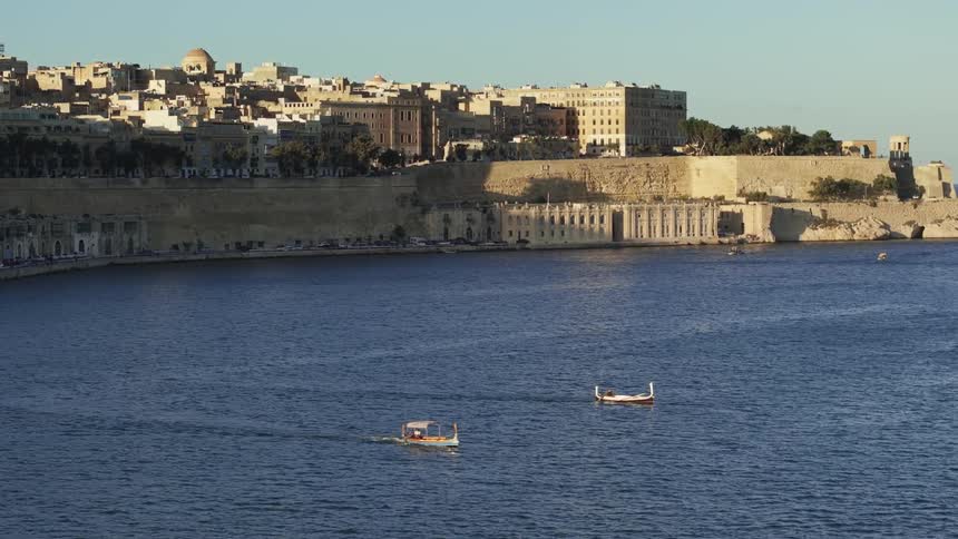 Aerial panorama of an ancient city by the sea with boats passing by