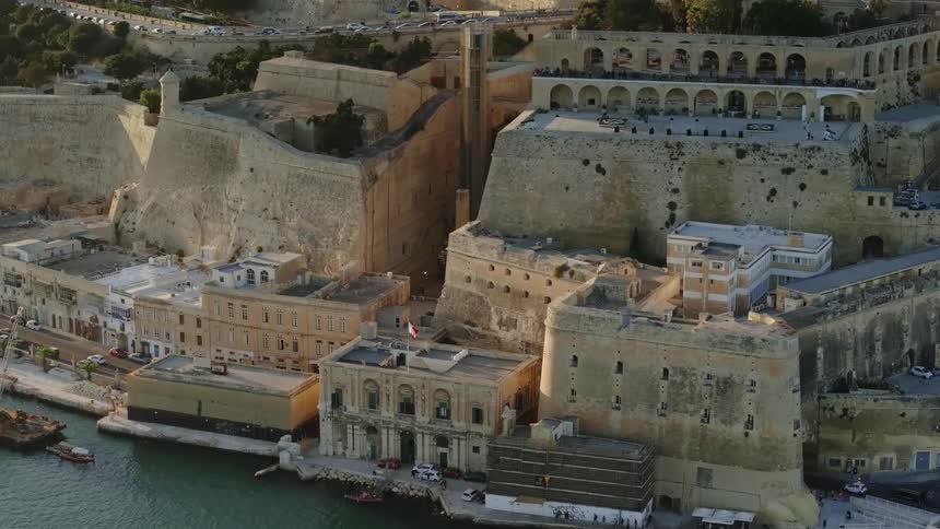 Old stone buildings are on the shore