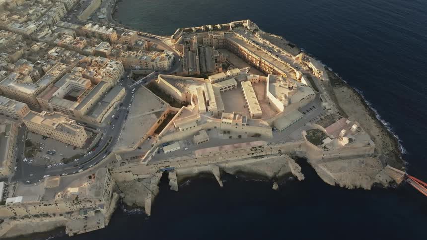 Aerial view of a star shaped structure and adjoining complex on the sea fort st elmo in malta at sunset