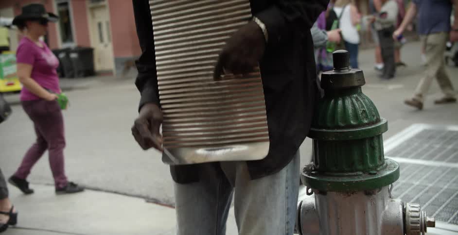 Man playing a washboard on the street corner downtown