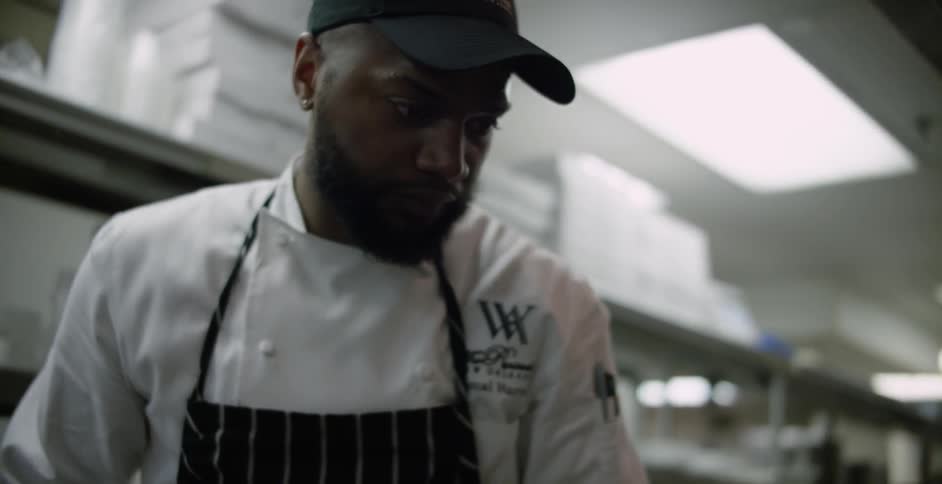 A chef plates a plate of food in a restaurant kitchen