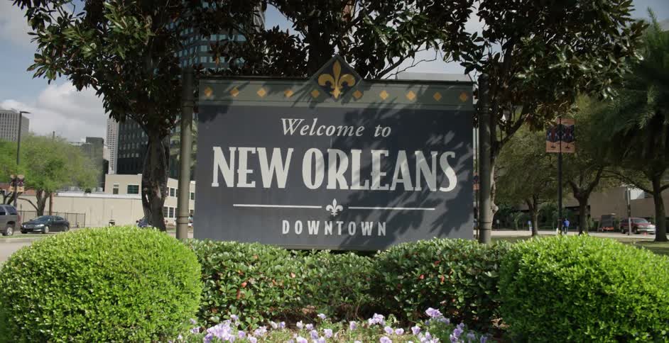 A sign is near an intersection that says welcome to new orleans