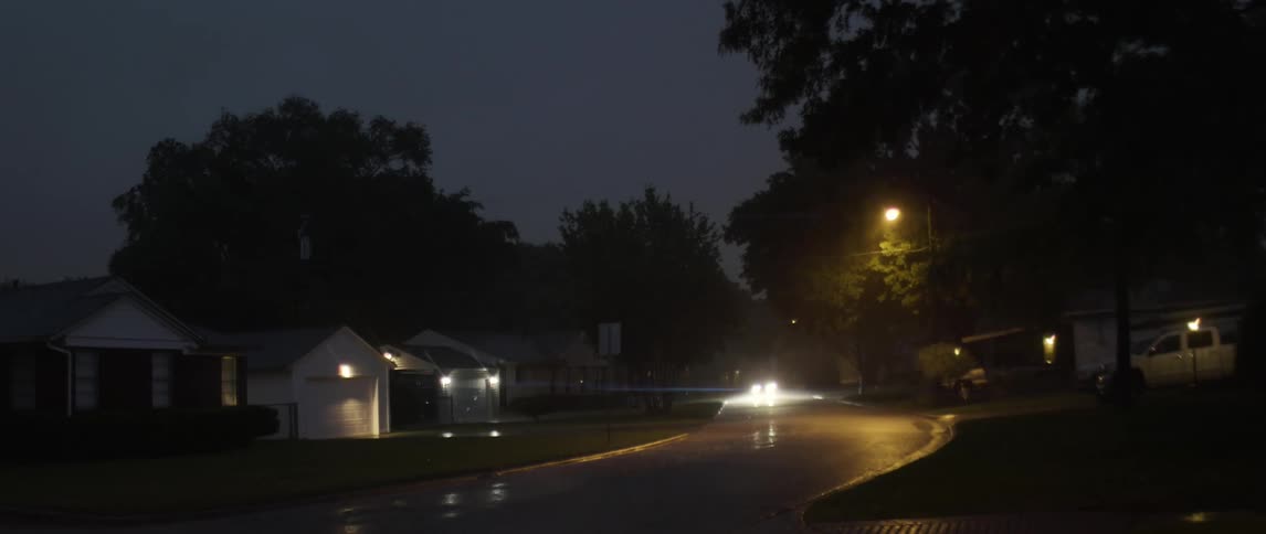A car comes down a winding road at night