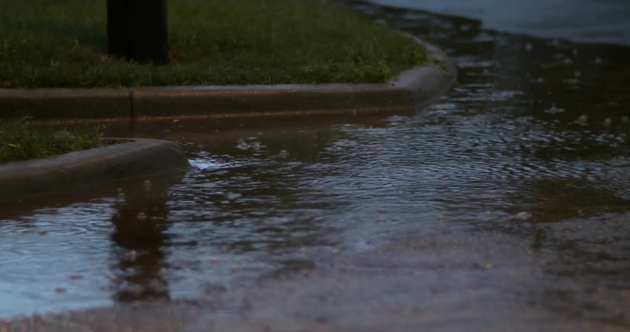 The rain pours down forming a puddle around the corner