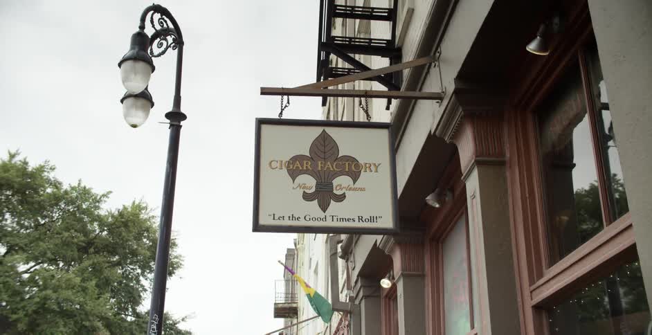 A shop sign is hanging on the side of a building