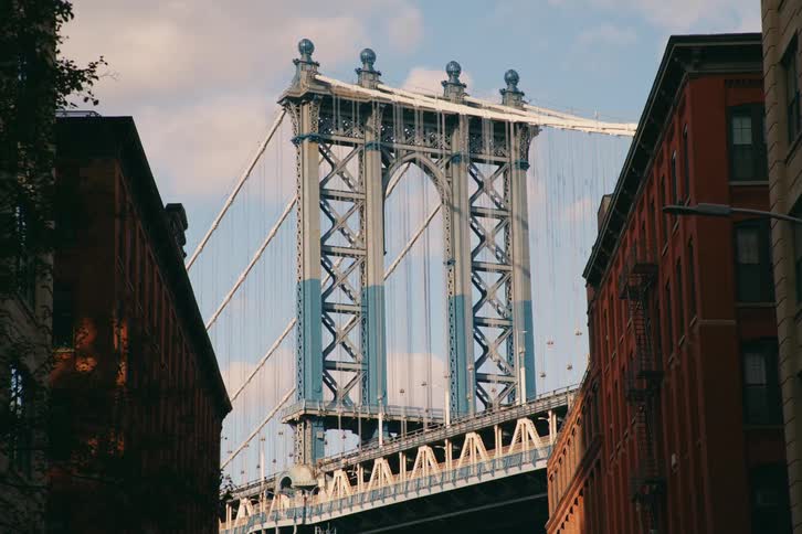 View of residential buildings with a bridge behind during a cloudy day