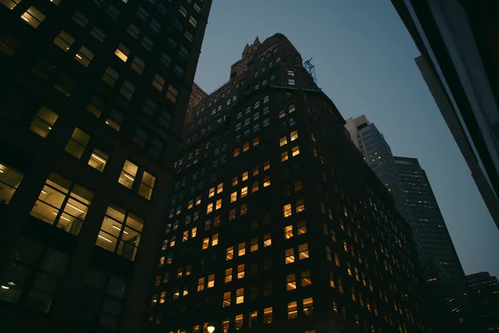 Upward view of a commercial building with lights on at night